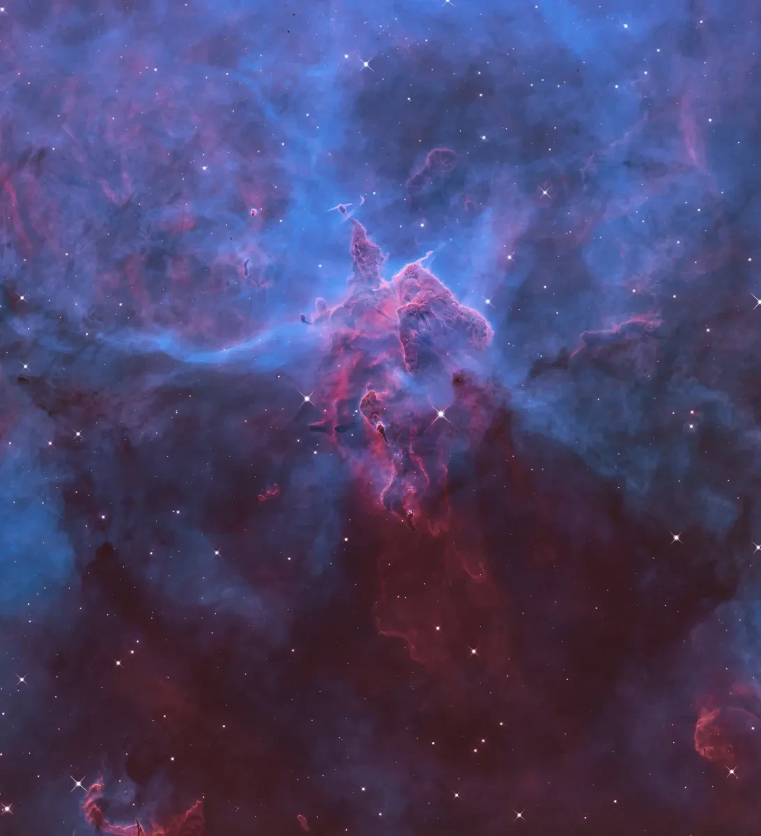 Vivid blue and purple rendering of a Hubble image of a nebula, with stars smattered around the image